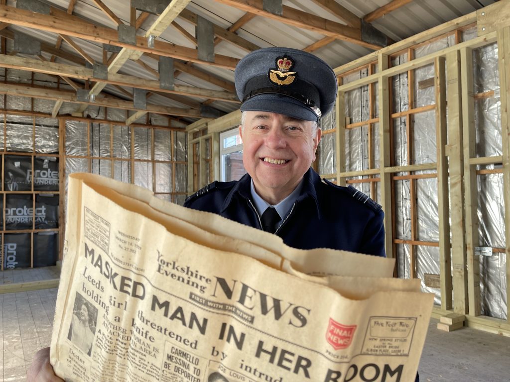 Steve Dunn holding a copy of the Yorkshire Evening News from 1959 which was found in the walls.