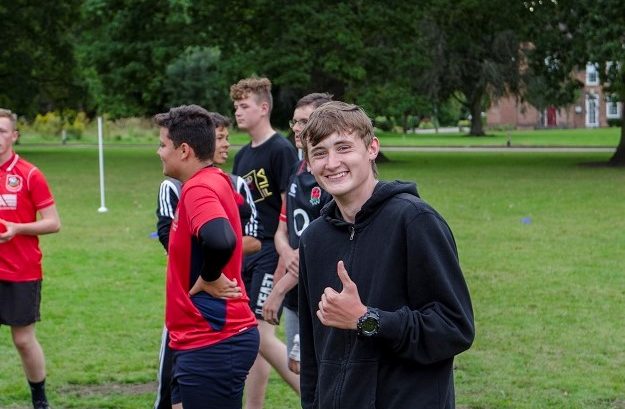 Smiling cadet playing football on camp