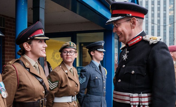 Female reserve smiling at Lord Lieutenant during ceremonial line-up