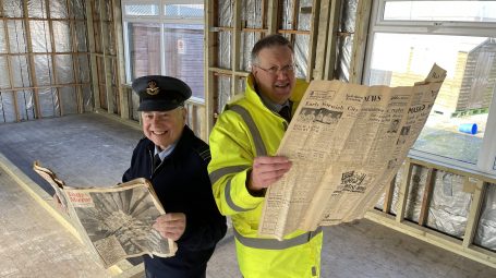 Two men appear reading newspapers in building under redevelopment