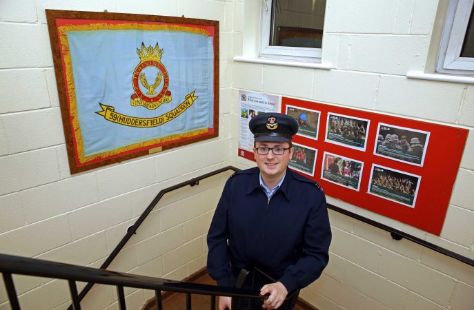 RAF cadet volunteer smiles in cadet centre staircase