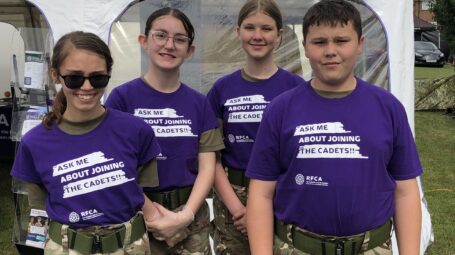 four smiling cadets standing in a row