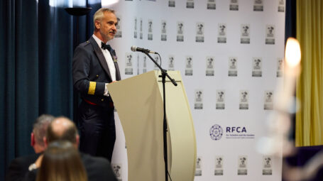 A man in uniform standing behind a lectern