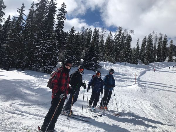 Four men in skiing clothing on a snowy mountain
