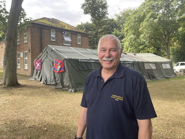 Man with tent behind him