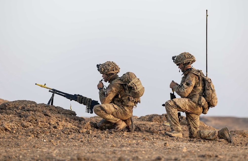 Two soldiers manning a gun in the desert