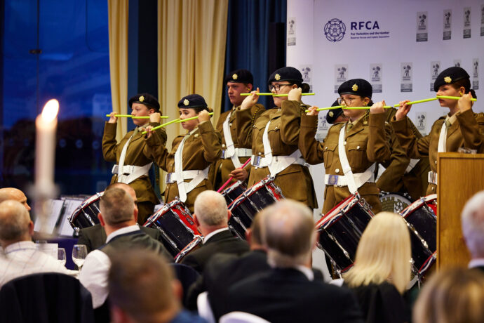 young people dressed in army cadet uniform playing instruments