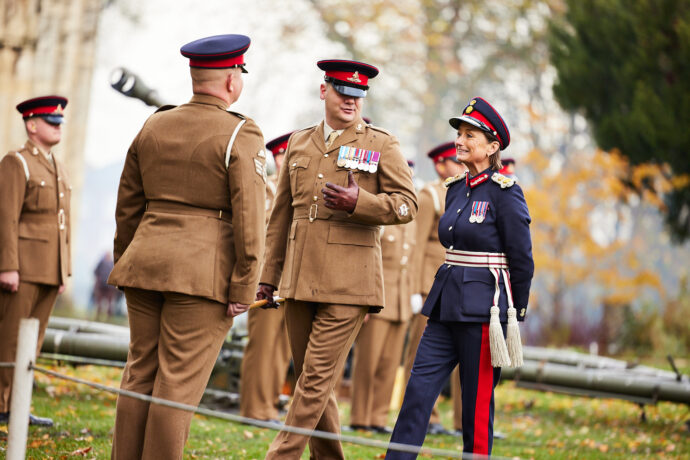 A woman in uniform chats to soldiers in uniform