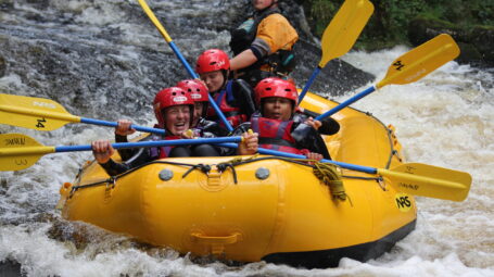young people white water rafting on a river