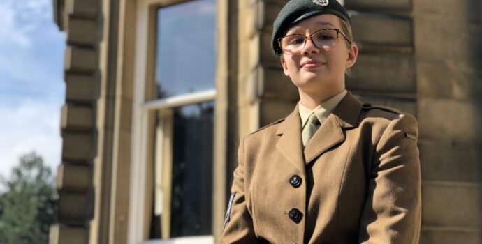 Charley Foster-Tomlinson in her army cadet uniform standing in front of a building in the sunlight