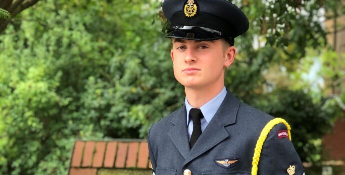 Cadet Freddie Thomlinson dressed in air cadet uniform standing in front of some greenery