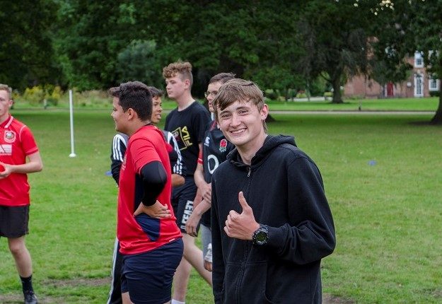 Smiling cadet playing football on camp