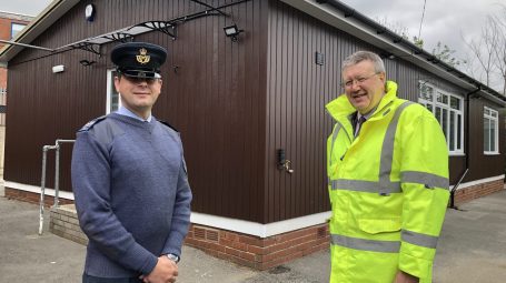 Air Cadet adult volunteer with man in high visibility jacket outside hut